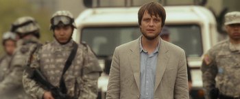 Movie still from “Salt” (2010), directed by Phillip Noyce – A man wearing a suit and tie standing in front of a truck; Close Up shot, Over the shoulder angle