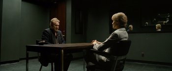 Movie still from “Salt” (2010), directed by Phillip Noyce – A man and a woman sitting at a table in front of each other; Medium shot, Over the shoulder angle