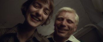 Movie still from “Salt” (2010), directed by Phillip Noyce – A man and a woman smiling for the camera; Close Up shot, Overhead angle