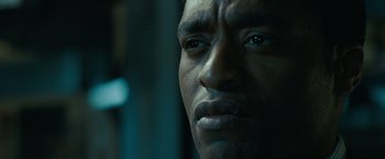 Movie still from “Salt” (2010), directed by Phillip Noyce – A man's face in a dark room; Close Up shot, Over the shoulder angle