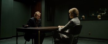 Movie still from “Salt” (2010), directed by Phillip Noyce – A man and a woman sitting at a table in front of each other; Medium shot, Over the shoulder angle