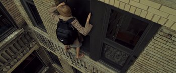 Movie still from “Salt” (2010), directed by Phillip Noyce – A person with a back pack climbing a window ledge; Wide shot, Overhead angle