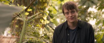 Movie still from “Salt” (2010), directed by Phillip Noyce – A man standing next to a bush in a forest; Close Up shot, Over the shoulder angle