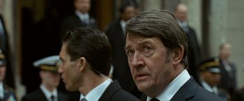 Movie still from “Salt” (2010), directed by Phillip Noyce – A man in a suit and tie next to another man in a suit and tie; Close Up shot, Over the shoulder angle