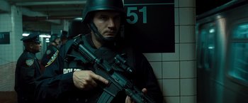 Movie still from “Salt” (2010), directed by Phillip Noyce – A man holding a gun in a room; Medium shot, Low angle