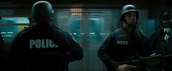 Movie still from “Salt” (2010), directed by Phillip Noyce – Two police officers standing in front of a subway train; Medium shot, Low angle