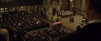 Movie still from “Salt” (2010), directed by Phillip Noyce – An overhead view of people in a church with a casket in the foreground; Extreme Wide shot, High angle
