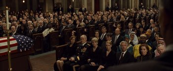 Movie still from “Salt” (2010), directed by Phillip Noyce – A group of people sitting in rows of pews; Wide shot, High angle
