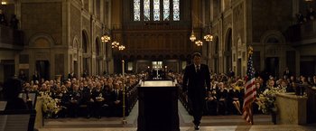 Movie still from “Salt” (2010), directed by Phillip Noyce – A man walking in front of an audience in a church; Wide shot, Low angle