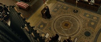 Movie still from “Salt” (2010), directed by Phillip Noyce – A man in a black suit standing in front of an organ; Extreme Wide shot, Overhead angle