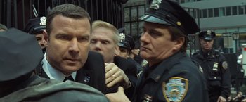 Movie still from “Salt” (2010), directed by Phillip Noyce – A group of men in police uniforms are gathered together; Close Up shot, Over the shoulder angle