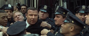 Movie still from “Salt” (2010), directed by Phillip Noyce – A group of men in police uniforms are gathered together; Medium shot, Over the shoulder angle