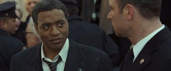 Movie still from “Salt” (2010), directed by Phillip Noyce – A man wearing a suit and tie talking to another man; Close Up shot, Over the shoulder angle