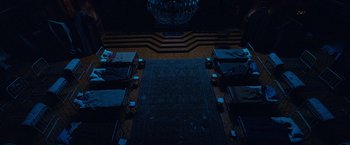Movie still from “Salt” (2010), directed by Phillip Noyce – A room filled with tables and chairs and a rug; Extreme Wide shot, Overhead angle