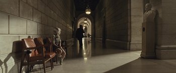 Movie still from “Salt” (2010), directed by Phillip Noyce – A person sitting on a chair in a hallway; Wide shot, High angle