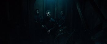 Movie still from “Salt” (2010), directed by Phillip Noyce – A group of men holding guns in a dark room; Wide shot, Low angle
