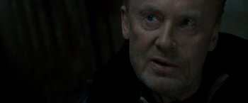 Movie still from “Salt” (2010), directed by Phillip Noyce – A man's face in the dark; Close Up shot, Over the shoulder angle