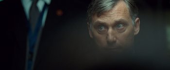 Movie still from “Salt” (2010), directed by Phillip Noyce – A person's face in a dark room; Close Up shot, Over the shoulder angle