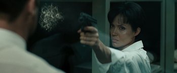 Movie still from “Salt” (2010), directed by Phillip Noyce – A woman holding a gun in front of a window; Close Up shot, Over the shoulder angle