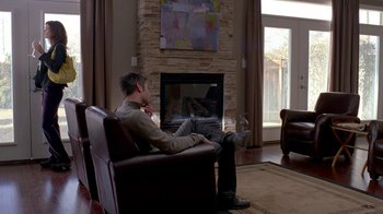 Movie still from “Breaking Bad” (2008), created by Vince Gilligan – A man sitting in a chair in front of a fire place; Wide shot, Over the shoulder angle