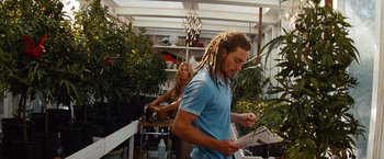 Movie still from “Savages” (2012), directed by Oliver Stone – A man and a woman are looking at plants; Medium shot, Low angle