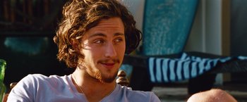 Movie still from “Savages” (2012), directed by Oliver Stone – A person with long curly hair; Close Up shot, Over the shoulder angle