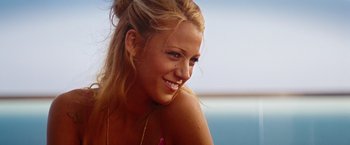 Movie still from “Savages” (2012), directed by Oliver Stone – A beautiful blond woman smiling at the beach; Close Up shot, High angle
