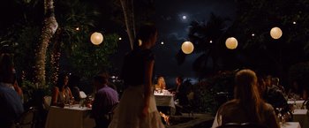 Movie still from “Savages” (2012), directed by Oliver Stone – People are sitting at a table outside at night; Wide shot, Over the shoulder angle