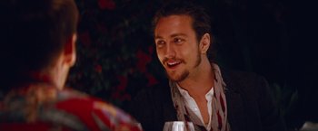 Movie still from “Savages” (2012), directed by Oliver Stone – A person sitting at a table with a glass of wine; Close Up shot, Over the shoulder angle