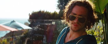 Movie still from “Savages” (2012), directed by Oliver Stone – A person wearing sunglasses near a waterfall; Close Up shot, Over the shoulder angle