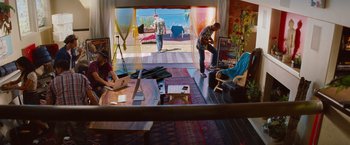 Movie still from “Savages” (2012), directed by Oliver Stone – Two people are sitting in a living room; Wide shot, High angle