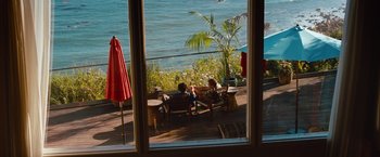 Movie still from “Savages” (2012), directed by Oliver Stone – Two people are sitting on a deck by the water; Wide shot, High angle