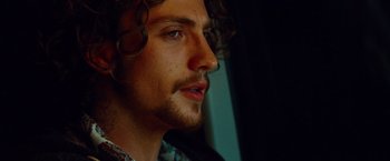 Movie still from “Savages” (2012), directed by Oliver Stone – A person with curly hair; Close Up shot, Low angle