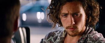 Movie still from “Savages” (2012), directed by Oliver Stone – A person with long curly hair; Close Up shot, Over the shoulder angle