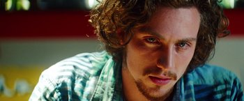 Movie still from “Savages” (2012), directed by Oliver Stone – A man's face with curly brown hair; Close Up shot, Low angle