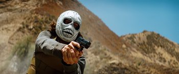 Movie still from “Savages” (2012), directed by Oliver Stone – A person wearing a mask and holding a gun; Medium shot, Low angle