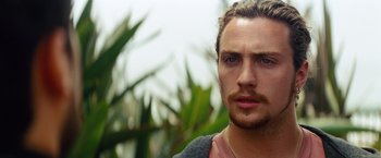 Movie still from “Savages” (2012), directed by Oliver Stone – A person with a beard looking at the camera; Close Up shot, Low angle