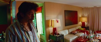 A man standing in a living room next to a lamp