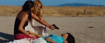 Movie still from “Savages” (2012), directed by Oliver Stone – A woman is holding a cell phone up to another woman's face; Medium shot, High angle