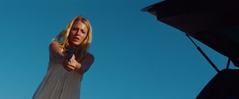 Movie still from “Savages” (2012), directed by Oliver Stone – A woman holding a gun in her hand; Medium shot, Low angle