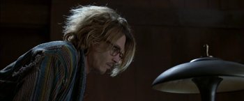 Movie still from “Secret Window” (2004), directed by David Koepp – A man with long blonde hair and glasses looking at a lamp; Close Up shot, Low angle