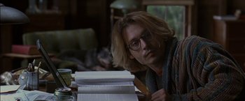 Movie still from “Secret Window” (2004), directed by David Koepp – A man sitting at a table with a cat in the background; Close Up shot, Over the shoulder angle