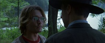 Movie still from “Secret Window” (2004), directed by David Koepp – A man and a woman standing next to each other in front of trees; Close Up shot, Over the shoulder angle