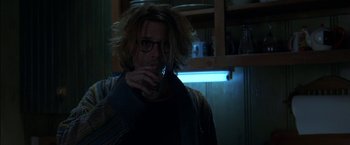 Movie still from “Secret Window” (2004), directed by David Koepp – A man drinking from a glass in a kitchen; Medium shot, Over the shoulder angle