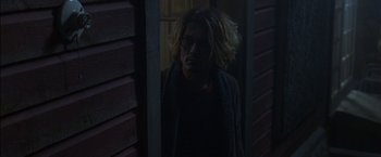 Movie still from “Secret Window” (2004), directed by David Koepp – A man standing in front of a door looking at the camera; Medium shot, Low angle