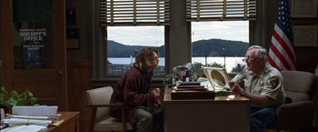 Movie still from “Secret Window” (2004), directed by David Koepp – A man sitting at a desk in front of a window; Wide shot, Over the shoulder angle