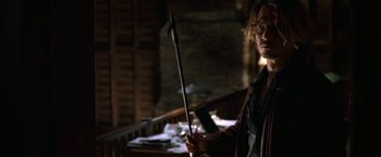 Movie still from “Secret Window” (2004), directed by David Koepp – A man holding a spear in a dark room; Medium shot, High angle