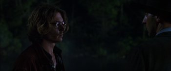 Movie still from “Secret Window” (2004), directed by David Koepp – A man with long hair wearing glasses and a black shirt; Close Up shot, Over the shoulder angle