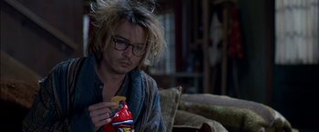 Movie still from “Secret Window” (2004), directed by David Koepp – A man sitting on a couch eating chips; Close Up shot, Overhead angle