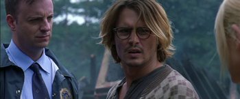 Movie still from “Secret Window” (2004), directed by David Koepp – A man with long blonde hair wearing glasses; Close Up shot, Over the shoulder angle